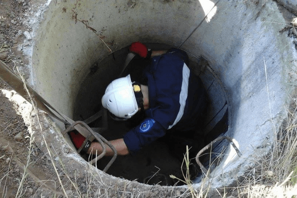 Fântână publică tradițională cu ghizd de beton, la marginea unei străzi