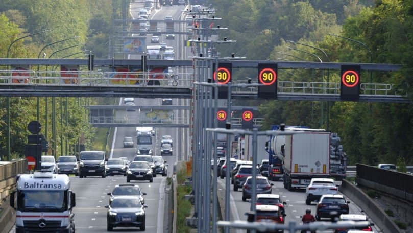 Autostradă în Belgia, cu mașini în trafic și un portal cu camere de supraveghere deasupra benzilor