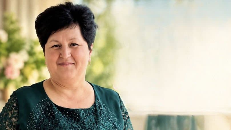 O sală de clasă goală dintr-o școală de la sat, cu bănci de lemn și tablă