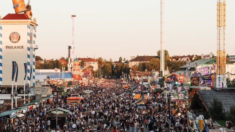 Halbe mari cu bere pe o masă de lemn, într-un cort de festival