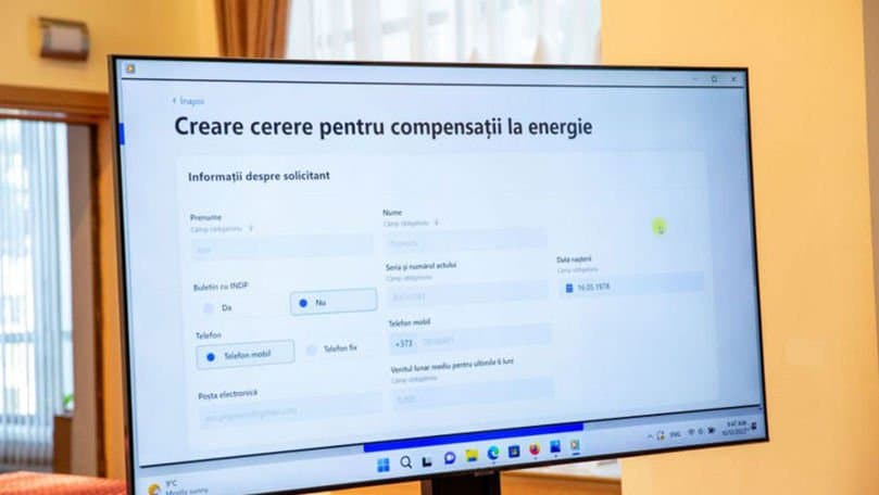 Mâna unei persoane reglează termostatul unui calorifer într-o locuință