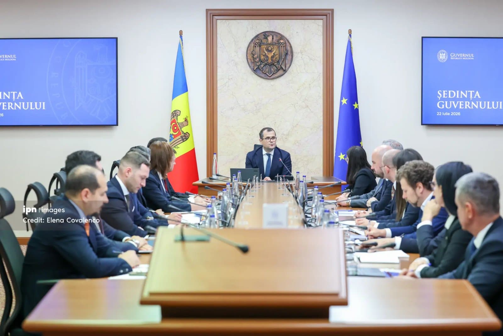 Un scaun cu rotile gol lângă o masă pe care se află documente și formulare de pensie