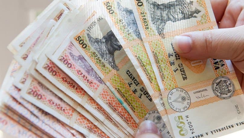 Bancnote moldovenești în lei și un fluturaș de salariu pe o masă