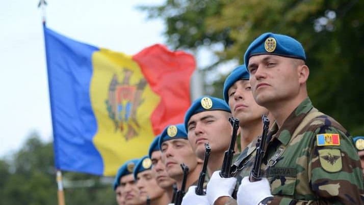 Militari în uniformă aliniați în timpul unei ceremonii, fotografiați din spate