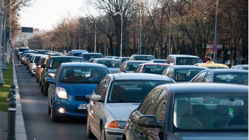 Șir de autoturisme blocate în trafic pe un bulevard aglomerat dintr-un oraș