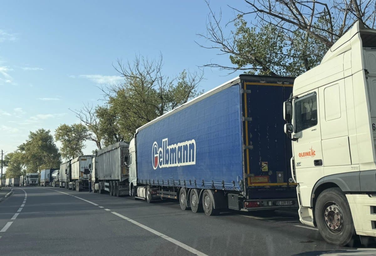Coloană lungă de camioane frigorifice care așteaptă la un punct de trecere a frontierei
