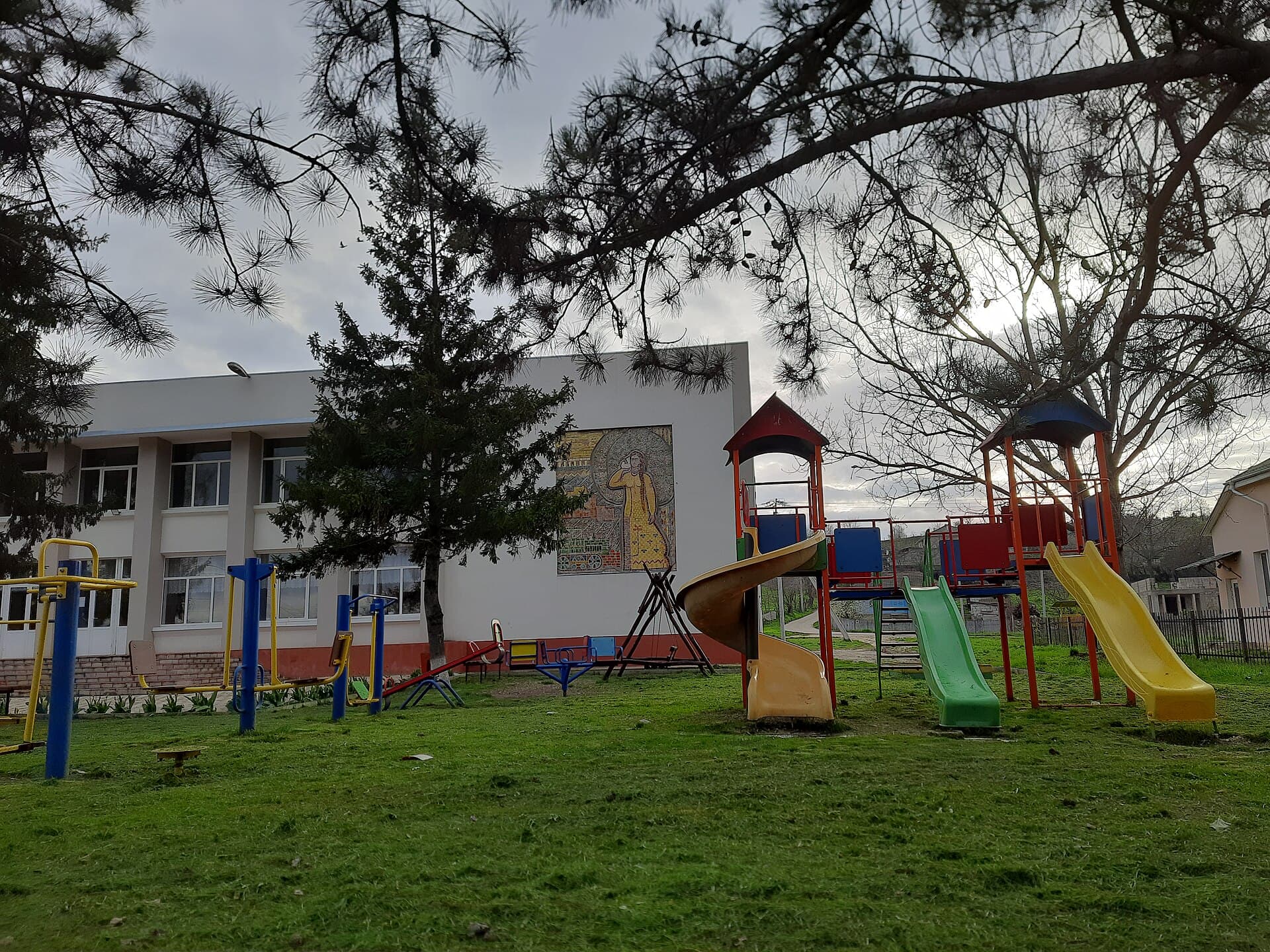 Femeie însărcinată care completează o cerere la masă, cu un calculator și documente alături